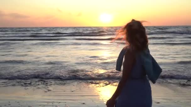 Active woman with sandals in hands walking near coastline of sea — 图库视频影像