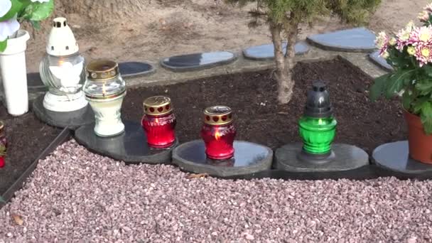 Lámpara de vela de vidrio y flores de crisantemo en lápida. Panorama. 4K — Vídeo de stock