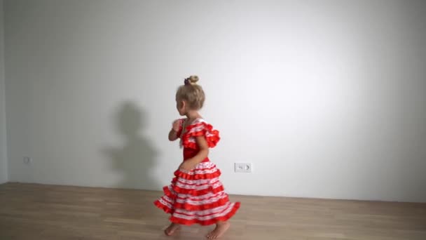 Excited little girl dancing with dress and shadow on background. Gimbal motion — ストック動画