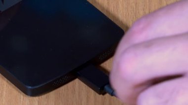 Male hand unplug micro usb cable from smart phone