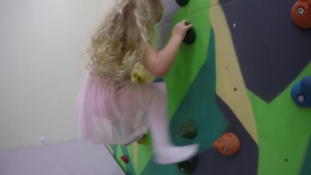 Jovem escalando em uma parede de escalada dentro de casa — Vídeo de Stock