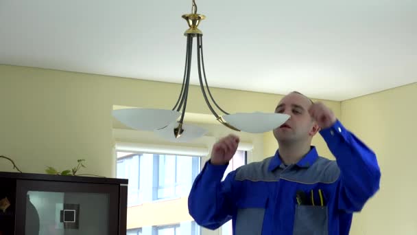 Man worker change economical light bulb in client apartment. 4K — Stock video