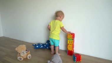 Evdeki bloklardan küçük şirin bir çocuk bina inşa ediyor. Gimbal hareketi