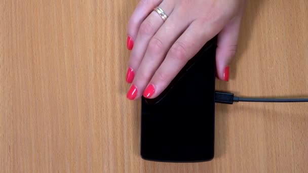 Kadın eli akıllı telefonu kablosuz şarj cihazına koydu. Yakın plan çekim. 4k — Stok video