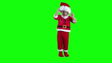 Sevimli sarışın çocuk Noel Baba şapkasını kafasına taktı. Yeşil krom anahtar arkaplanı