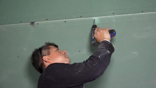杂工用累积器螺丝刀固定干墙至天花板 — 图库视频影像