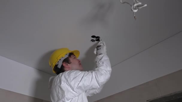 Obrero agujero de reparación en el techo para lámparas led. Nuevo apartamento de reparación, decoración. 4K — Vídeo de stock