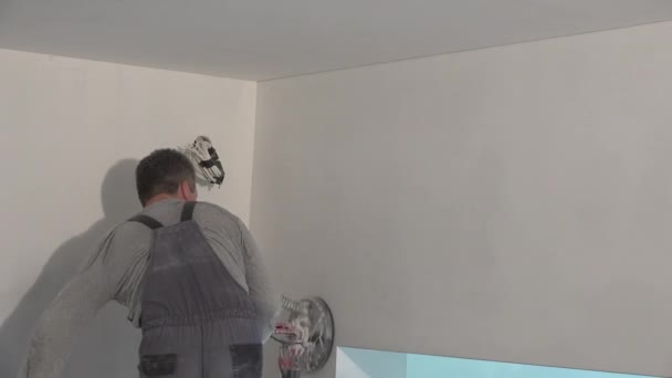 Schilder man met slijpmachine polijsten muur. uitzoomen — Stockvideo