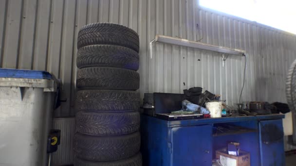 Carro mecânico segurar auto pneu na pilha. Estação de reparo de carro de trabalho. 4K — Vídeo de Stock