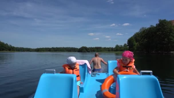 Gekke vader man sprong van catamaran in het water met twee kinderen zittend. Gimbal motie — Stockvideo