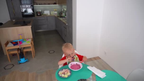 Menino comendo sopa fria de beterraba com batatas. criança com rosto sujo — Vídeo de Stock