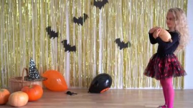 Sarışın, kıvırcık saçlı güzel kız Cadılar Bayramı için balkabağı süsleme odası