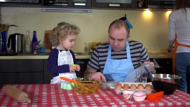 Отец читал рецепт кексов с дочерью. подготовка выпечки на кухне. 4K — стоковое видео