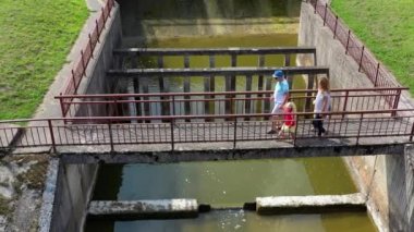Baraj köprüsünden geçen dört kişilik bir aile. Hava aracı görüntüsü