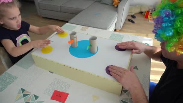 Padre con pelo de payaso y su hija jugando juego de mesa activo — Vídeos de Stock