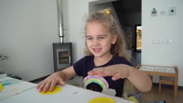 Linda niña rubia mostrando emociones positivas después de ganar juego de mesa hecho a mano — Vídeos de Stock