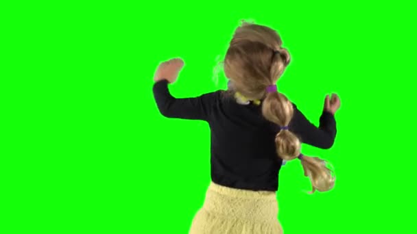 Сзади танцует пятилетняя девочка в черной рубашке и желтой юбке. Ключ хрома — стоковое видео