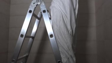 Elektrikçi merdivende durur ve kurşun lamba için tavandaki deliği yönetir. 4K