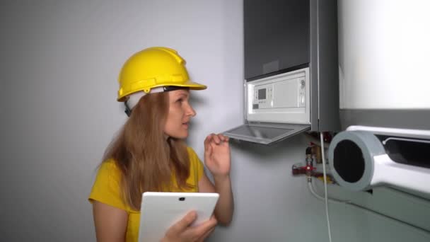 Skilled female heating specialist with tablet computer inspecting gas boiler — Stock Footage Skilled female heating specialist with tablet computer inspecting gas boiler Stock Footage