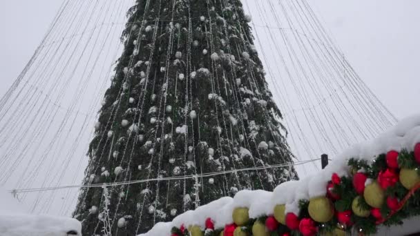 Árbol de Navidad con decoraciones en el fondo de una ciudad nevada. 4K — Vídeo de stock