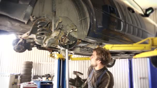 Auto monteur reparatie auto schorsing in auto tankstation. 4K — Stockvideo