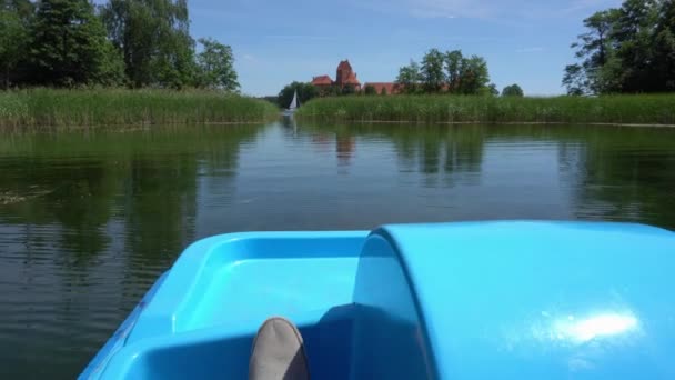 Pieds mâles en bottes de sport grises pédale en catamaran bleu cycle de l'eau. Gimbal — Video