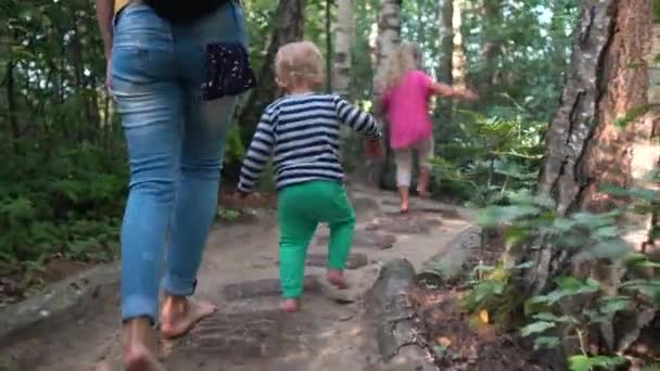 Mom with little son and daughter walking on healthy barefoot path — Stock Video