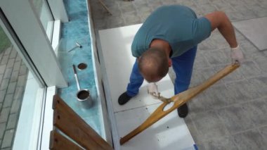 Boya fırçası kullanarak ahşap tahtayı cila yağıyla boyamış.