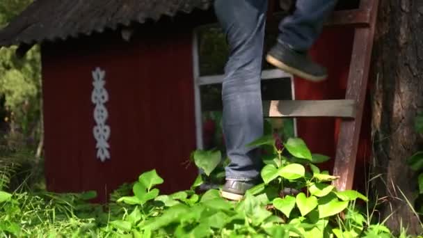 Homem pernas subindo na escada de madeira alta ao ar livre — Vídeo de Stock