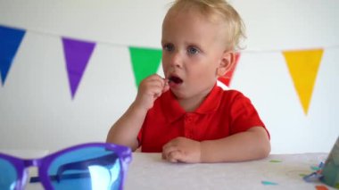 Çubuğunda şeker olan küçük bir çocuk. Doğum günü partisi sonrası. Gimbal hareketi