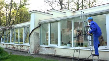 Merdivendeki işçiler, yüksek su basıncıyla kirli çatıyı temizlediler. 4K