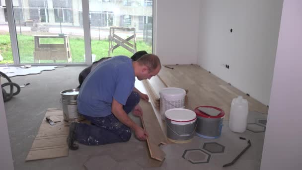 Tesaři instalovat parkety podlahy a hit s kladivem připojit lépe — Stock video