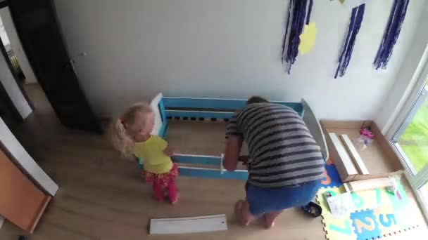 Man kvinna och barn bygga ny säng för pojke. Lycklig familj som arbetar tillsammans — Stockvideo