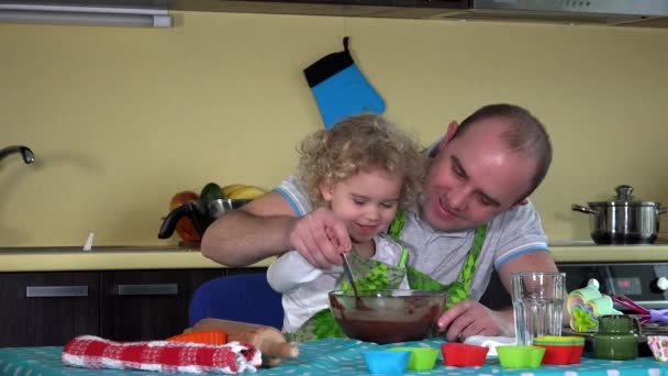 Vater und Tochter mischen in der Küche Schokoteig für Kuchen. 4K — Stockvideo