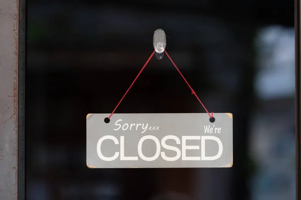 sorry we are closed sign hanging outside a restaurant, store, office or other