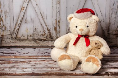 Oyuncak ayı ahşap kapı arka plan üzerinde Noel şapka ile