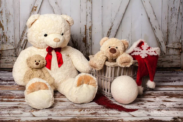 Two teddy bears with Christmas hats on wooden gate background — Stock Photo, Image