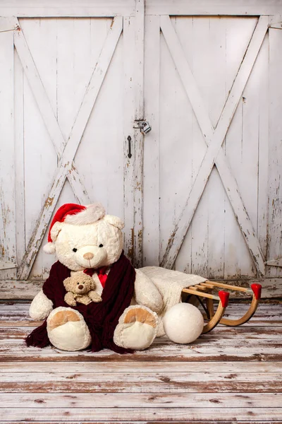 Dva medvídky s vánoční čepice na pozadí dřevěná brána, vintage — Stock fotografie