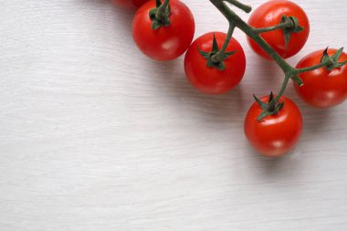 Beyaz ahşap zemin üzerinde parlak kırmızı sulu domates