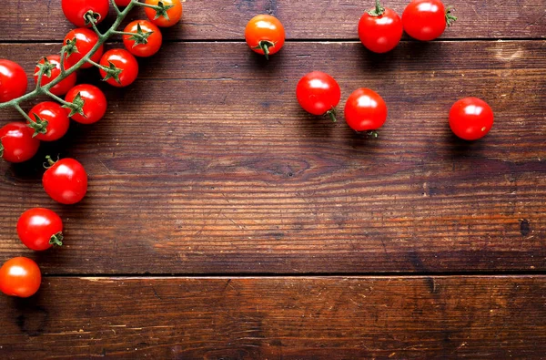 Bright red juicy tomatoes on textured wooden background