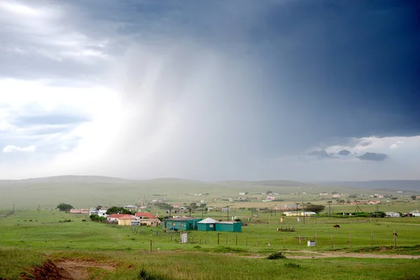 Huge rain storm over landscape in African village