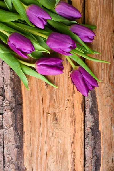 Ramo de tulipanes en mesa de madera vintage —  Fotos de Stock