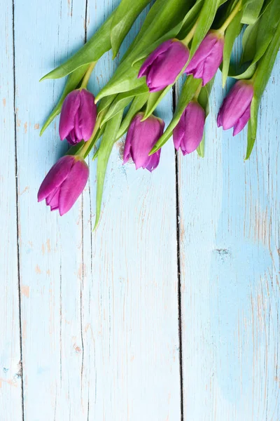 Kytice z tulipánů na retro dřevěný stůl — Stock fotografie