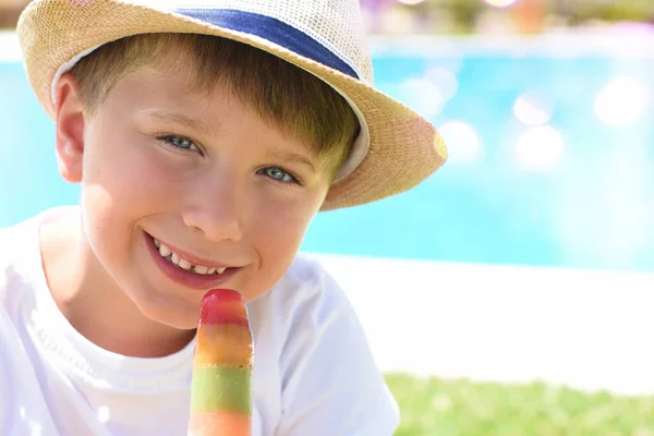 Schattige kleine jongen met ijs naast het zwembad — Stockfoto