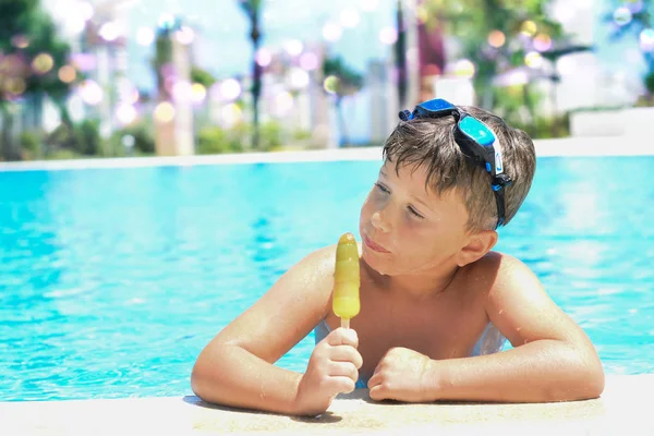 Mignon petit garçon avec crème glacée à côté de la piscine — Photo