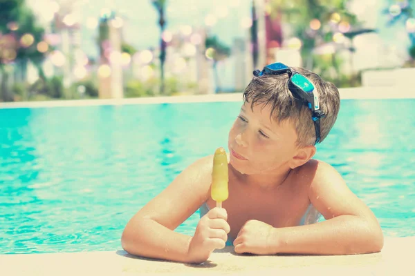 Ładny chłopczyk z lodami przy basenie — Zdjęcie stockowe