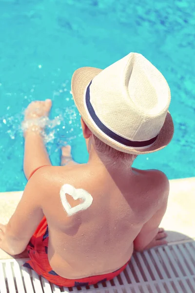 Little boy with hat next to the swimming pool — Stock Photo, Image