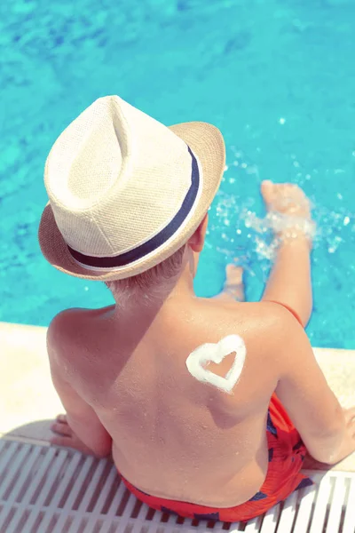 Little boy with hat next to the swimming pool — Stock Photo, Image