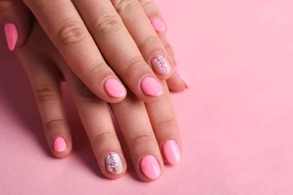 Pink manicure on female hand.