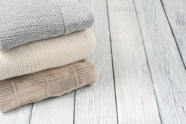 Örme kış giysileri ahşap zemin üzerine yığını